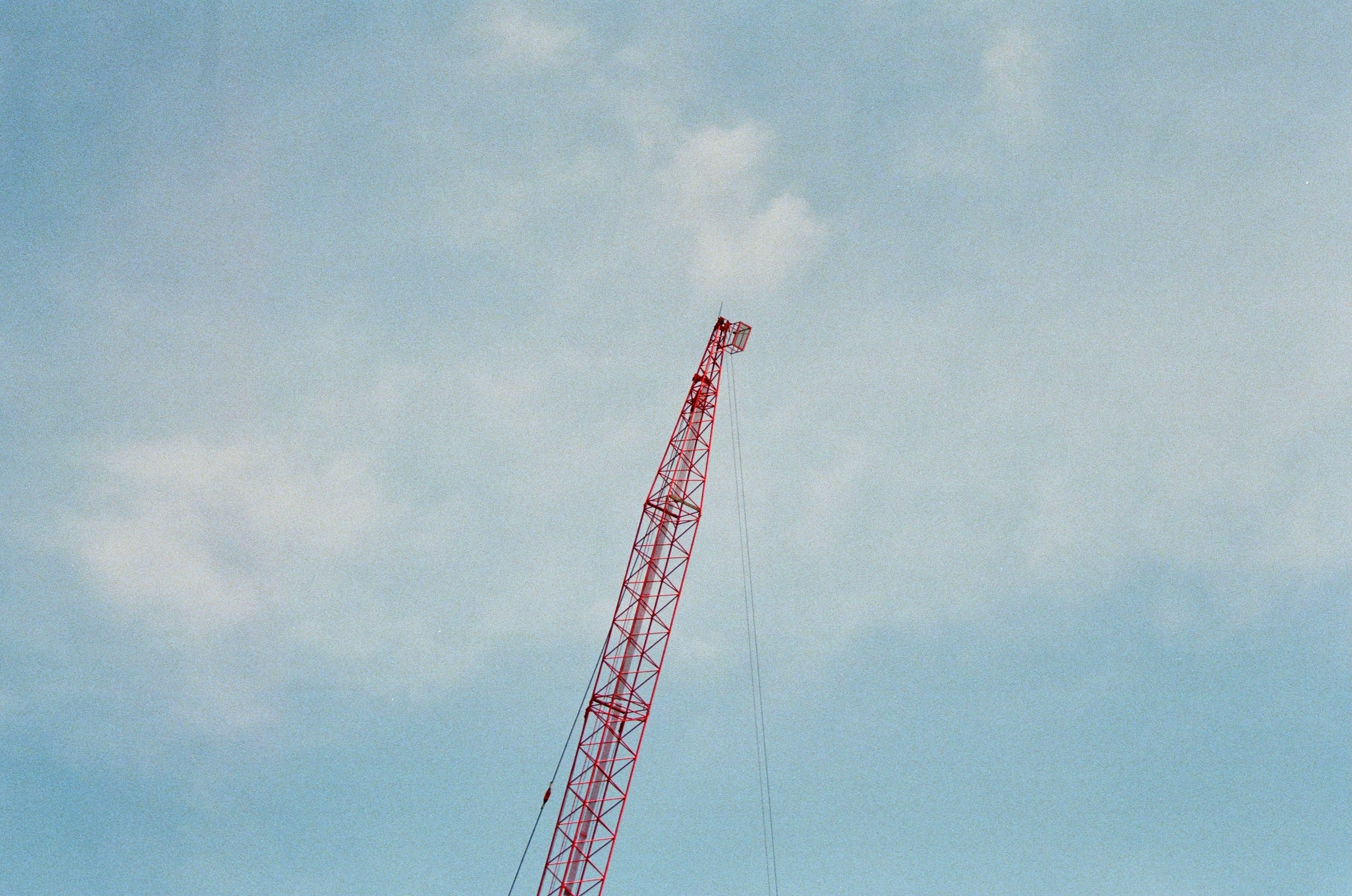 red metal crane under blue sky during daytime